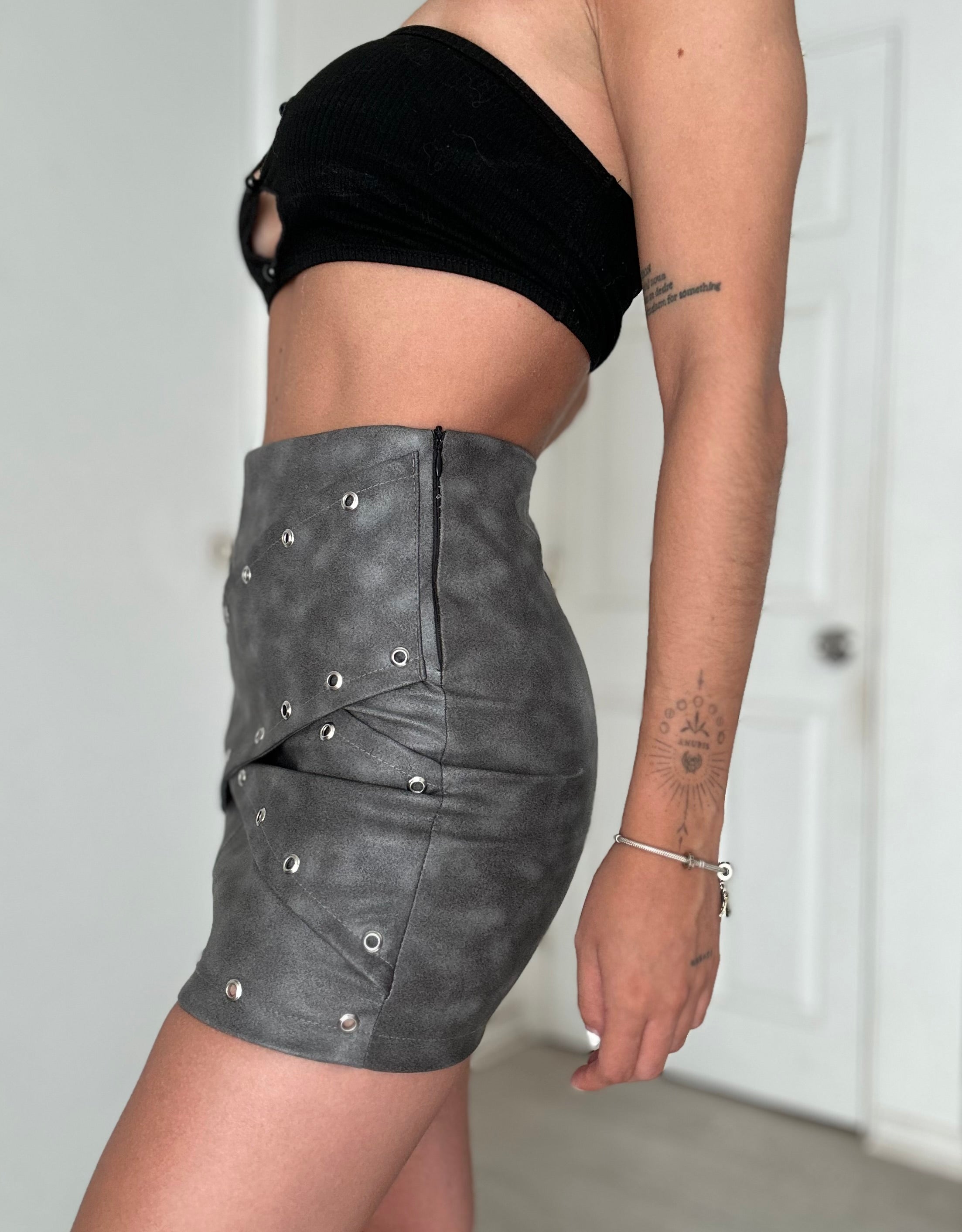 MINI FALDA CUERINA OJETILLOS